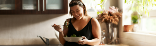 Smiling young woman eats a healthy meal in a sunny room