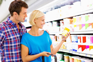 Woman Checking Product Nutrition Label With Man In Supermarket