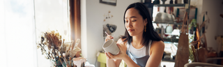 A woman relaxes and enjoys the creative outlet of ceramics in a bright, sunny art studio. 